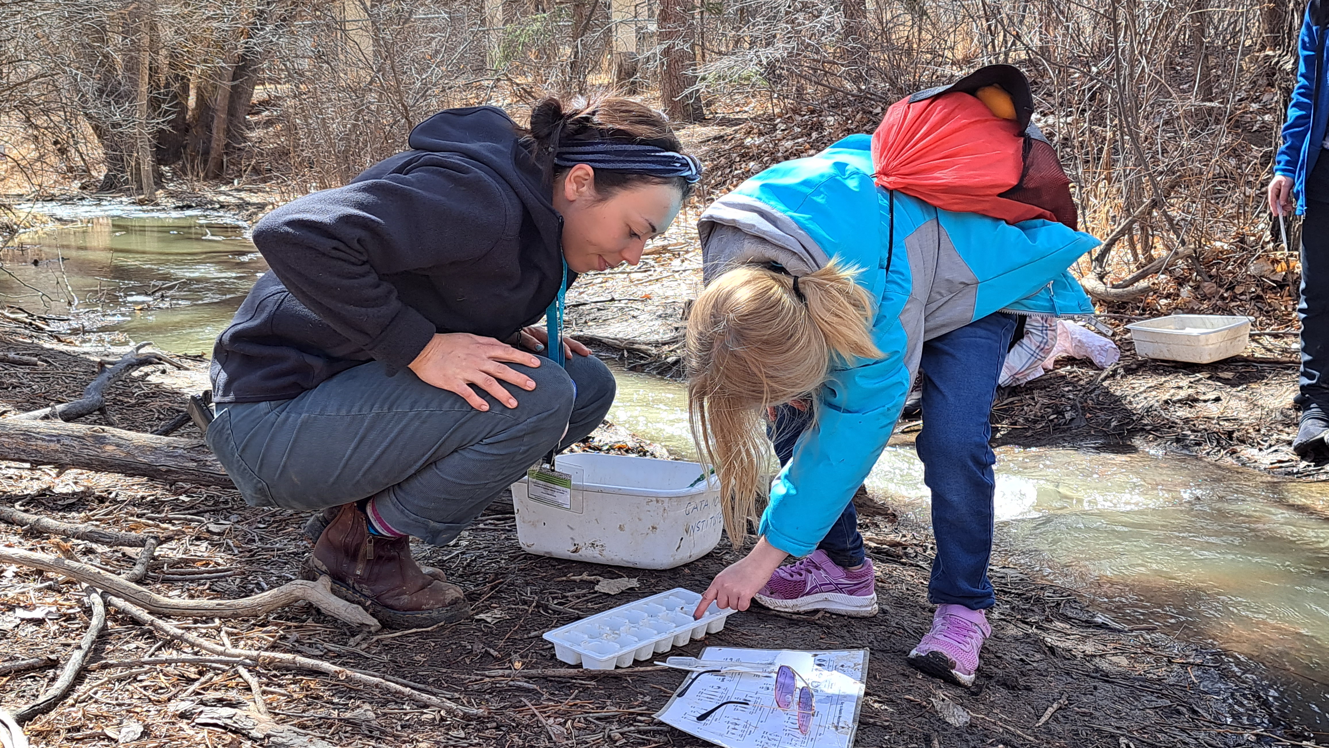 A student explores macroinvertebrates with the support of a Catamount AmeriCorps member