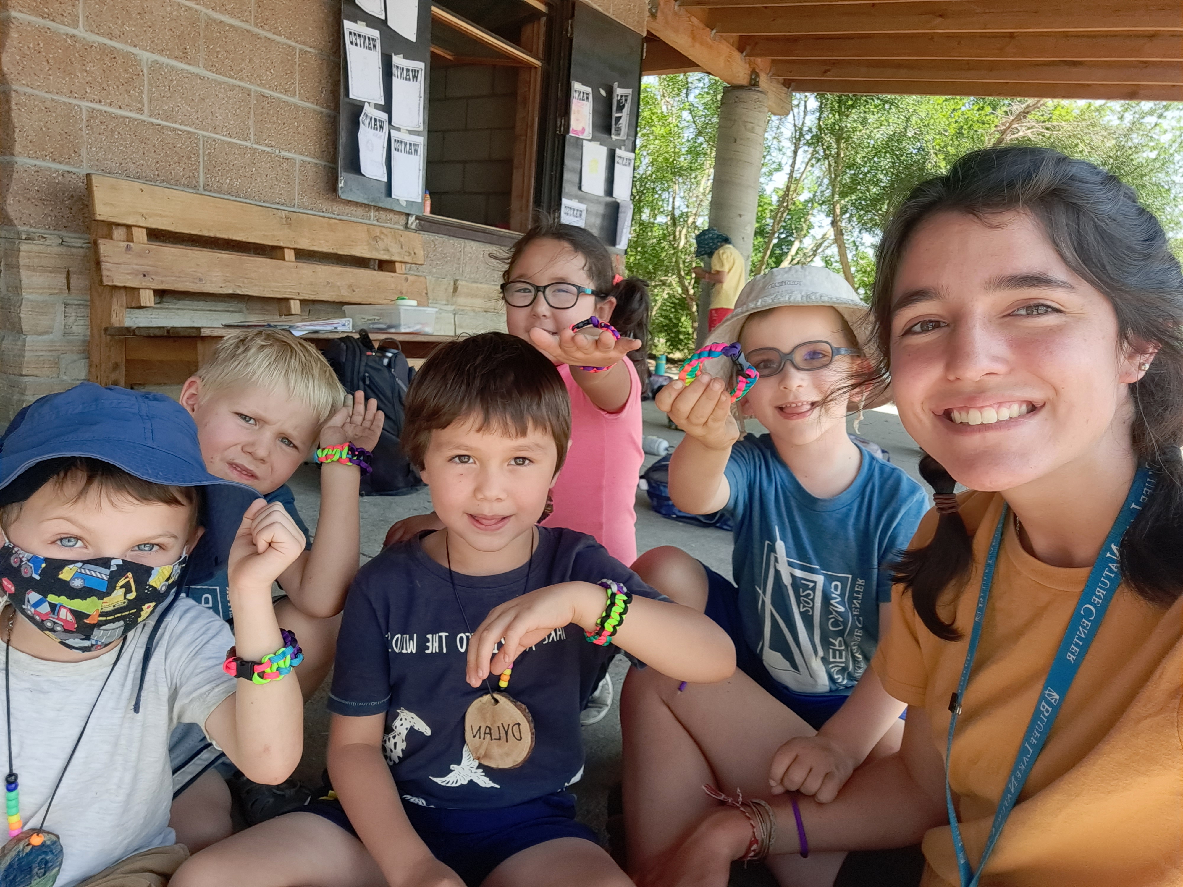 Students smile and show off their crafts with a Bluff Lake instructor